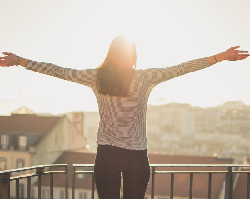 a woman spreading her arms on a fine morning